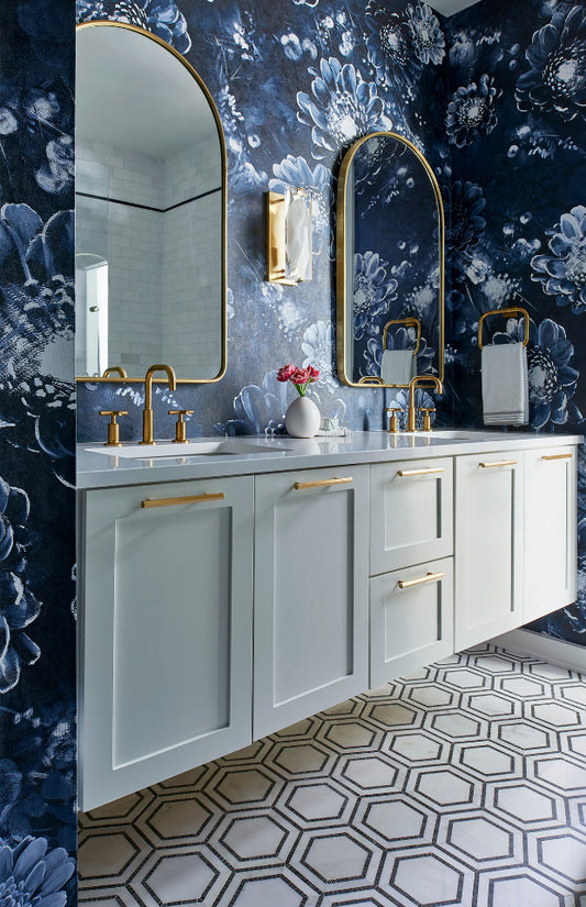 Ellie Cashman Moonlight Meadow Blue Wallpaper in powder room with white cabinets and gold fixtures