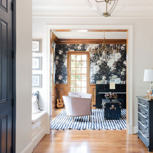 Dark Floral Wallpaper above wainscotting in a sunlit living room with light colors.