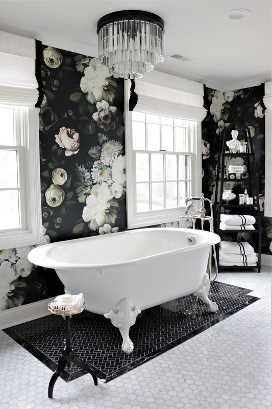 Dark Floral Wallpaper in bathroom with a freestanding bathtub, black and white tiles and decorative elements. 