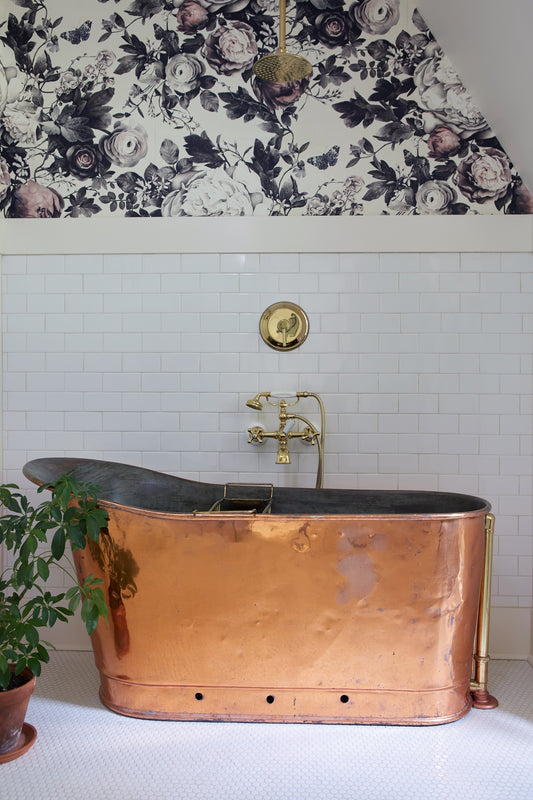 Floral Wallpaper in bathroom with copper bathtub white tiles