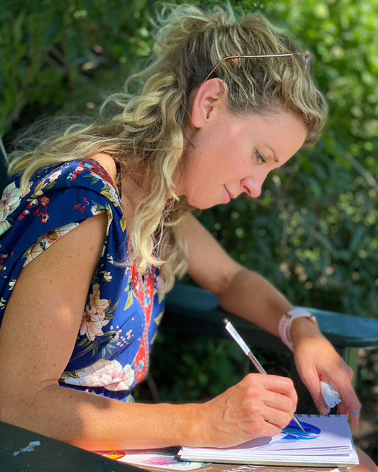 Portrait of artist Ellie Cashman painting in the garden